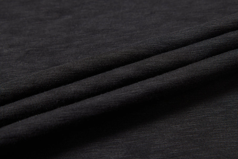 Close-up of washed black distressed graphic tee fabric with layered folds and textured knit detail