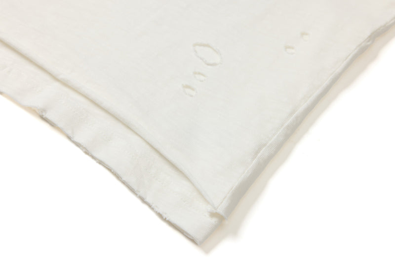 Folded off-white distressed graphic tee with subtle industrial print details on soft cotton fabric