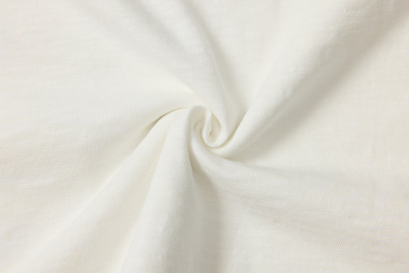 Close-up of soft white ribbed fabric with a central spiral fold and layered texture for a distressed graphic tee background