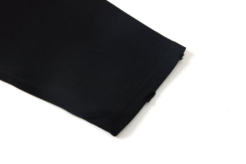 Black tee sleeve hem with raw distressed edge close-up
