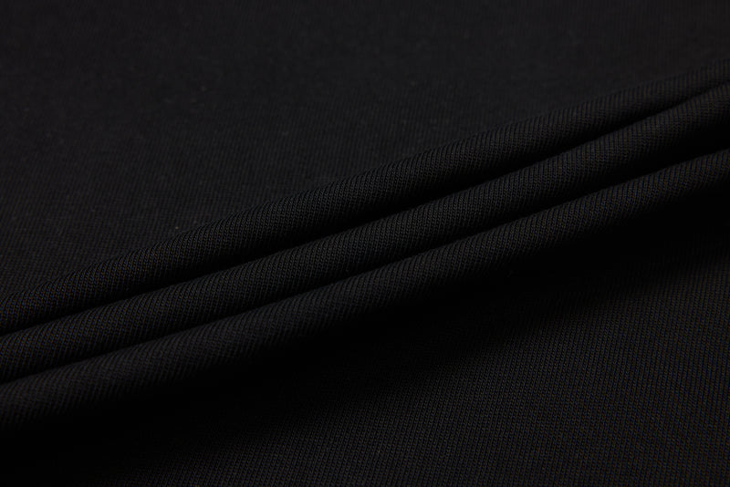 Black ribbed knit fabric draped in folds close-up
