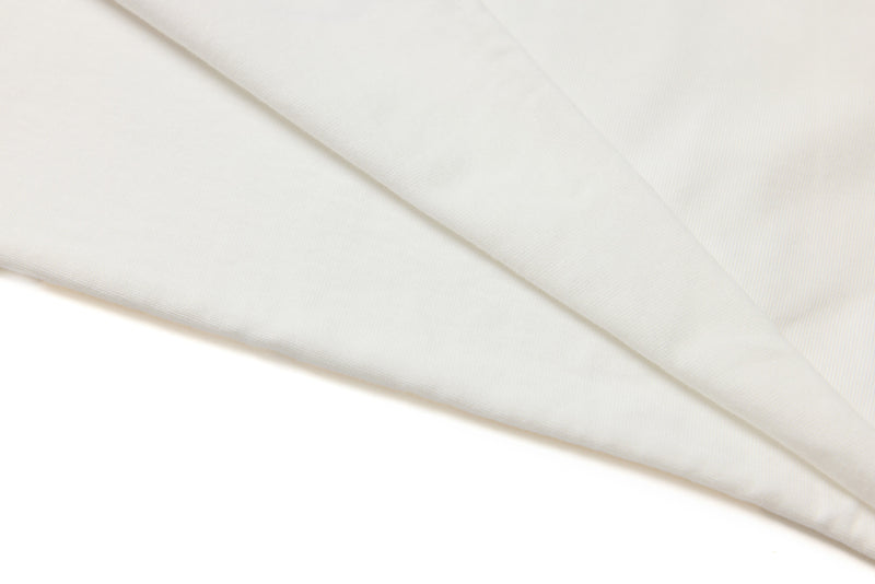 Close-up of white tee fabric fold showing smooth cotton texture