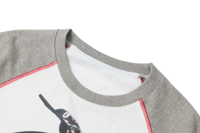 Close-up of the gray ribbed collar and red seam stitching on the raglan tee