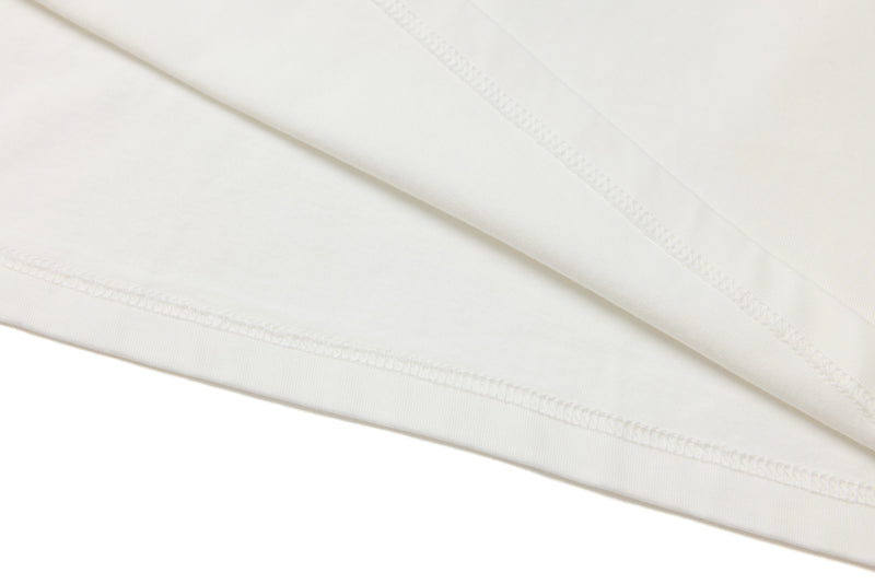 Close-up of white hem stitching on the tee body