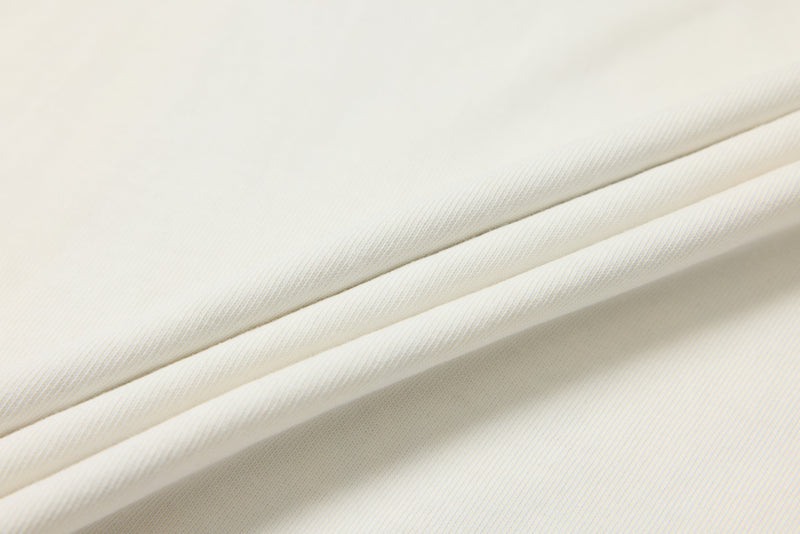 Close-up of soft white knit fabric folded in layers with fine ribbed texture