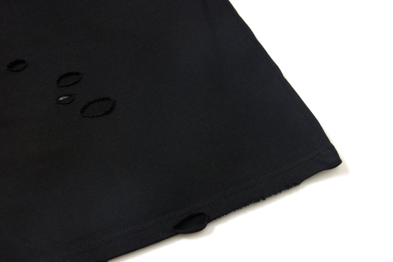 Black tee sleeve cuff with distressed holes close-up