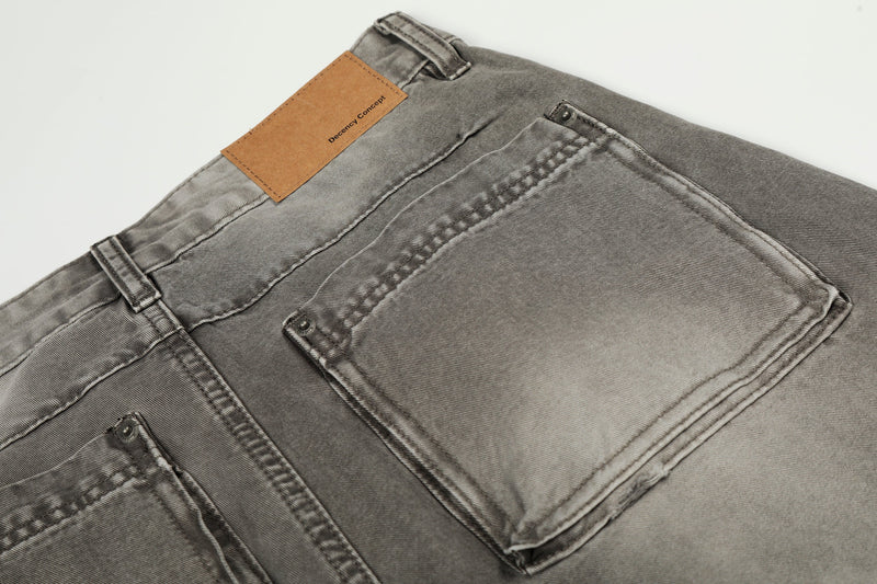 Close-up of back pocket and waistband on grey washed denim jeans with visible topstitching