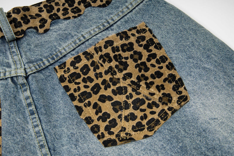 Close-up of back leopard print patch pocket on faded distressed denim shorts