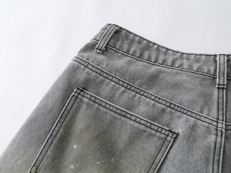 Close-up of back waistband and patch pocket seam on grey wash denim shorts