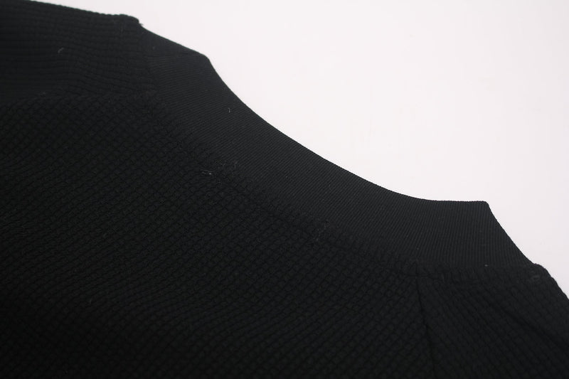 Black oversized textured graphic tee with a close-up of the ribbed shoulder and collar on a white background
