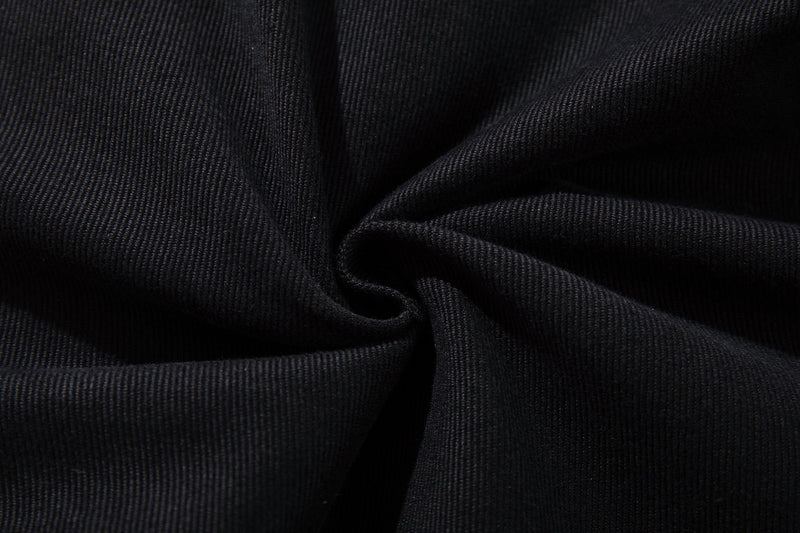 Close-up of black denim fabric texture with soft folds and ribbed weave