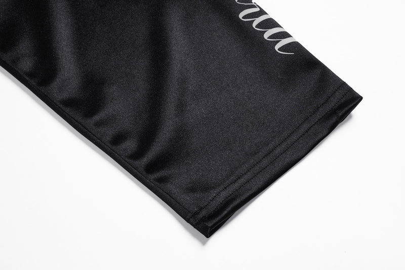 Black sleeve cuff close-up with smooth fabric and stitched hem