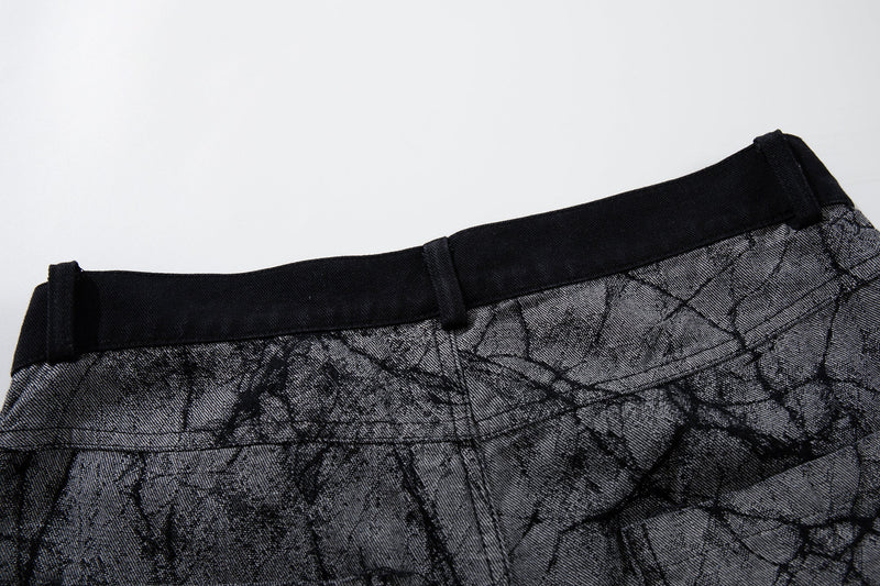 Close-up of back waistband on gray cracked-texture denim pants with black trim
