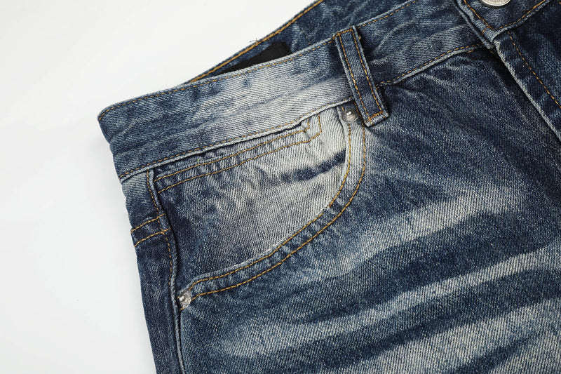 Close-up of front pocket seam on faded blue jeans with orange contrast stitching