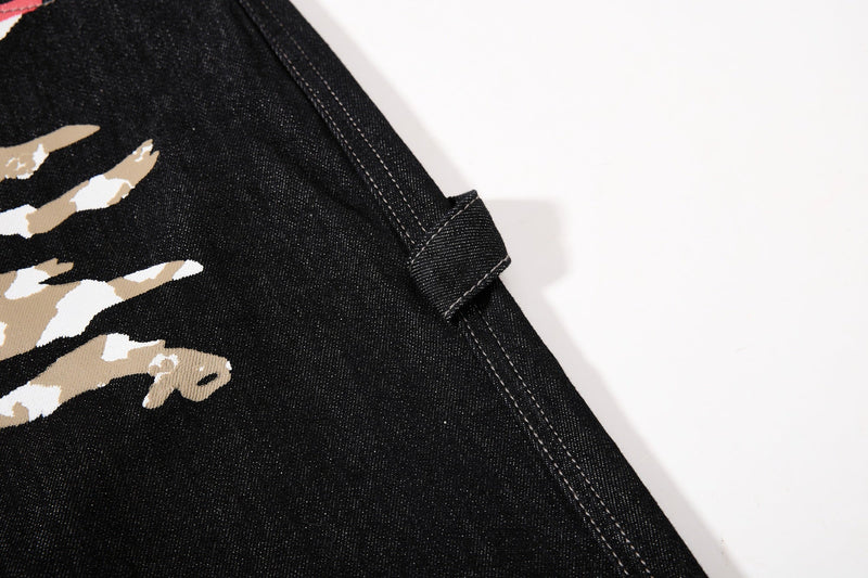 Side strap tab detail on black denim jeans with flag print