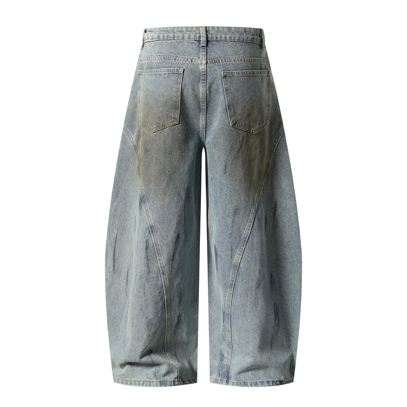 Back view of faded blue wide-leg denim pants with patch pockets and curved panel seams