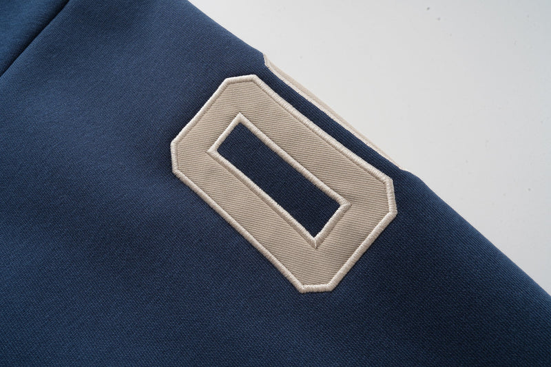 Close-up of tan number patch on navy hoodie sleeve