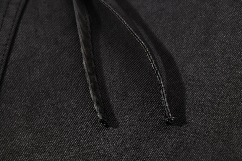 Close-up of black drawstring cords on the shorts leg