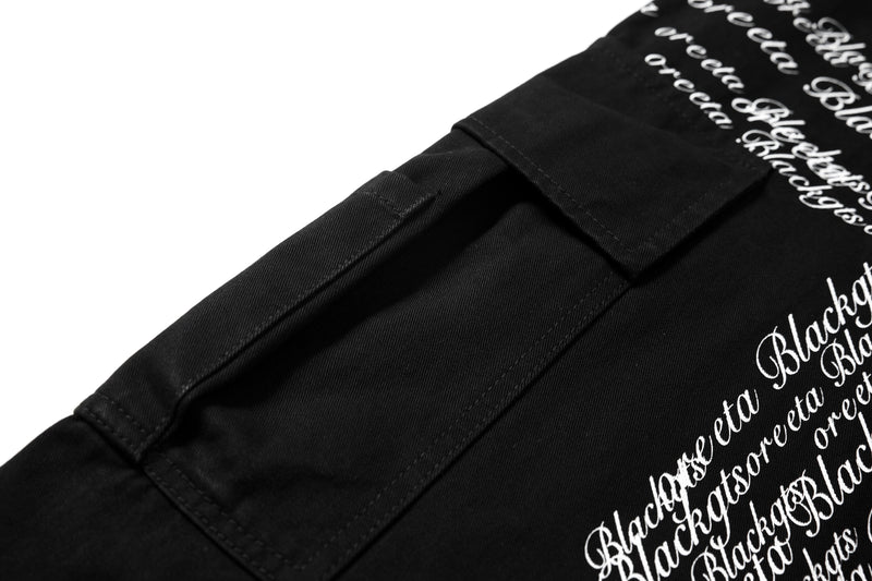 Close-up of black cargo pocket and side print detail on black pants
