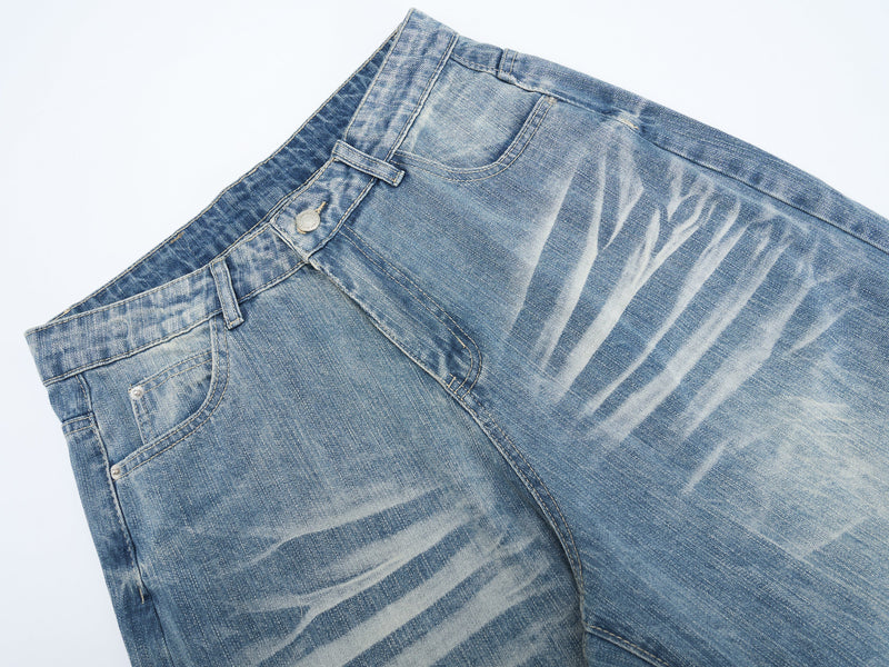 Close-up of the front waist on faded blue denim jeans showing belt loops, button fly, and pocket detail