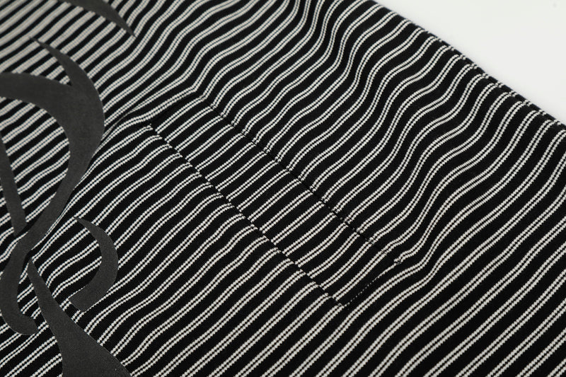 Close-up of striped fabric and seam detail on black zip hoodie