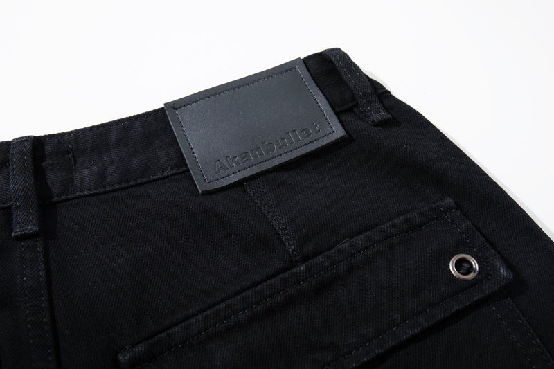 Close-up of black waistband with logo patch and front pocket edge