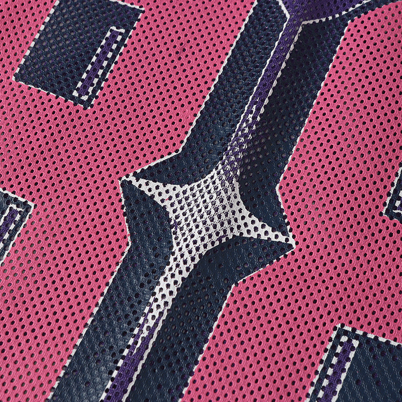 Close-up of pink mesh varsity jersey fabric with navy and white number 88 graphic detailing