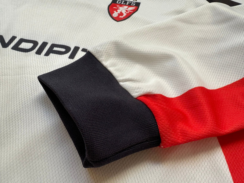 Close-up of black sleeve cuff and red side panel on white jersey fabric