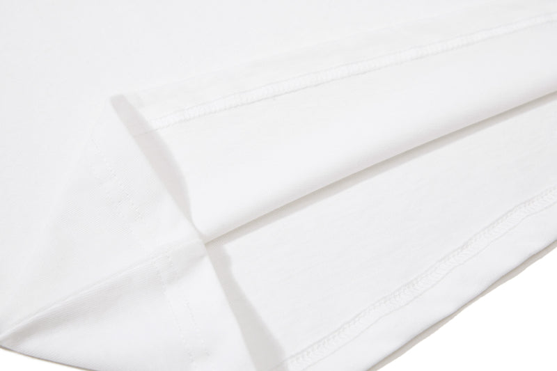 Close-up of a white cotton polo tee with visible sleeve and seam stitching on a clean background