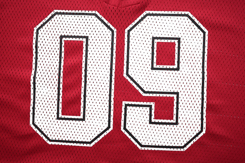Close-up of a red mesh hockey jersey with large white number 09 outlined in black