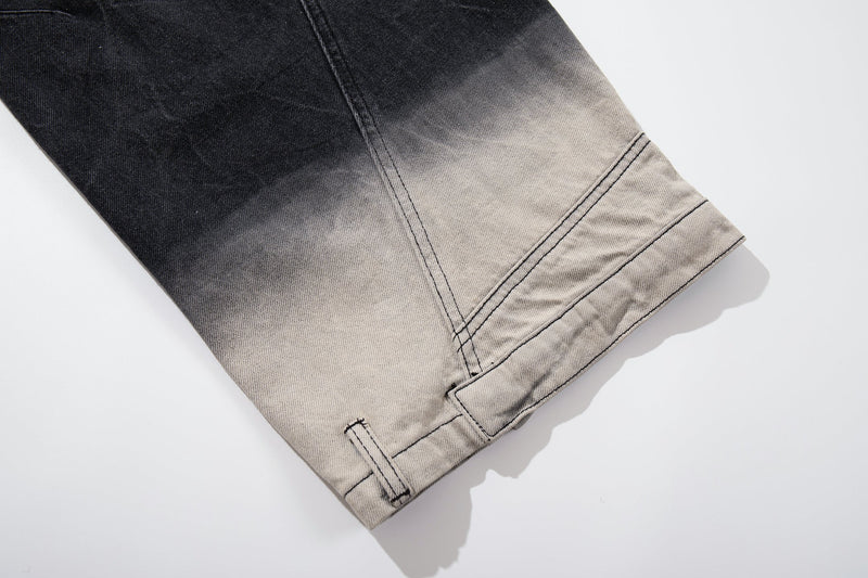 Close-up of the hem on black denim jeans with curved seam and stitched cuff detail