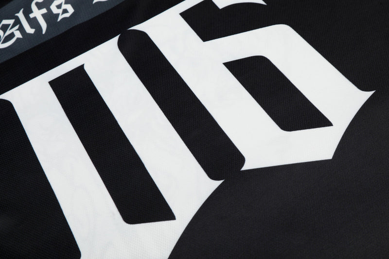 Close-up of black mesh football jersey with bold white gothic lettering and dark streetwear graphics