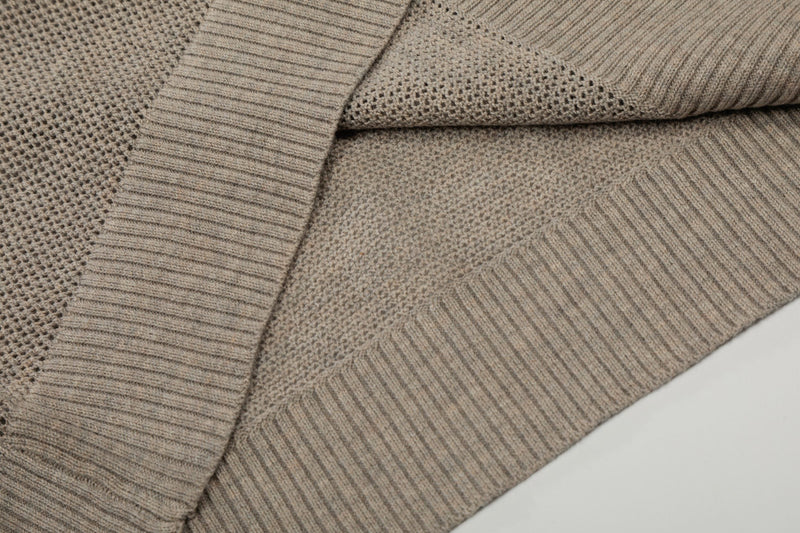 Close-up of beige open knit polo fabric with ribbed trim and breathable textured cotton weave
