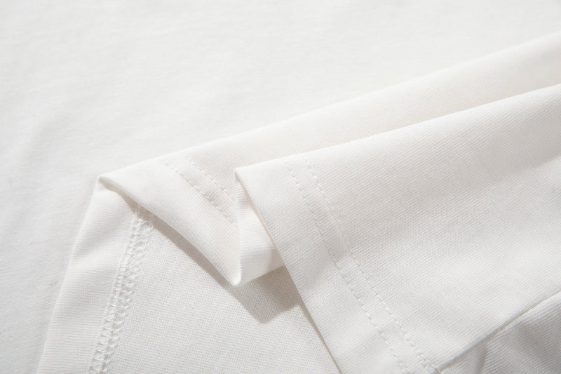Close-up of white polo shirt fabric and stitched sleeve hem with subtle textured knit detail