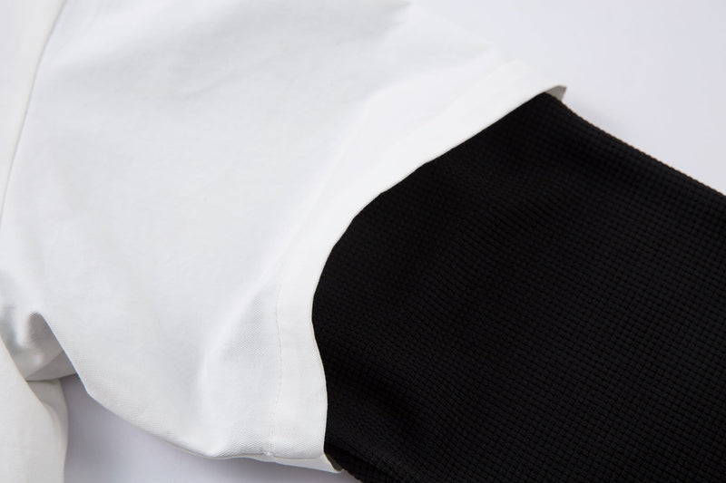Close-up of black layered long sleeve under white shirt sleeve