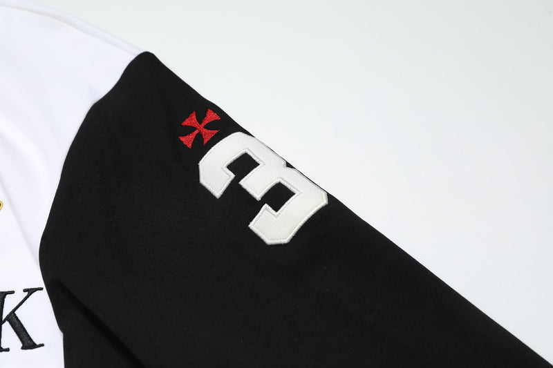 Close-up of black sleeve with white number 3 and small red cross emblem