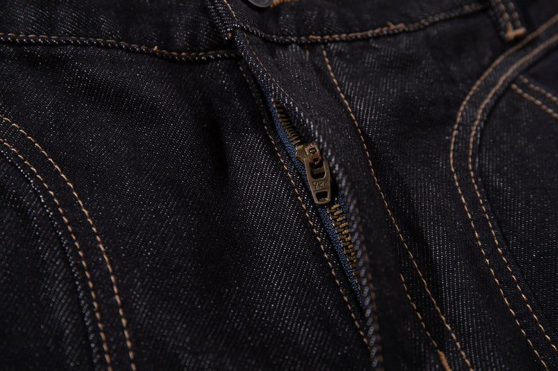 Close-up of dark wash denim waistband and zipper fly with contrast stitching