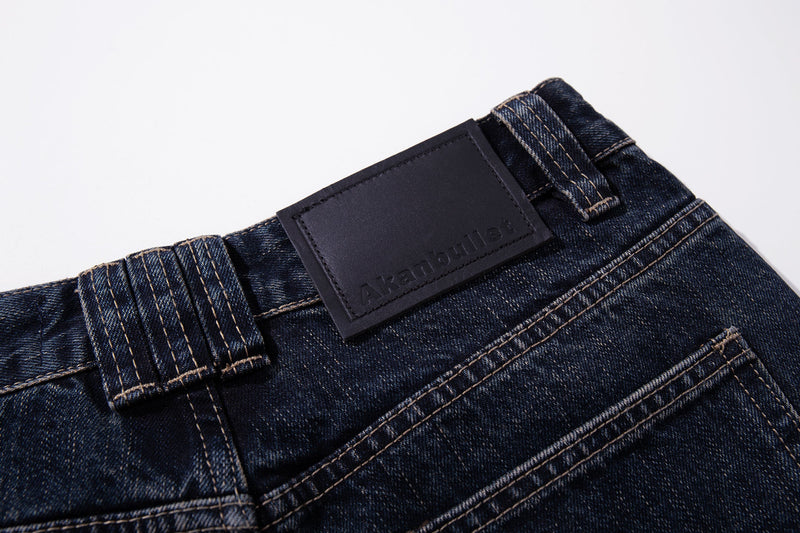Close-up of the back waistband leather logo patch on dark wash jeans