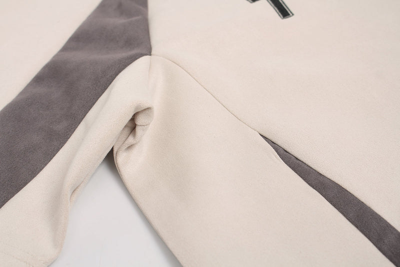Close-up of an ivory athletic streetwear tee with gray suede paneling and textured fabric details