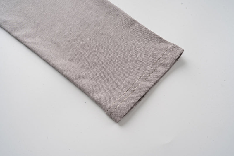 Gray long sleeve cuff close-up on layered camo tee