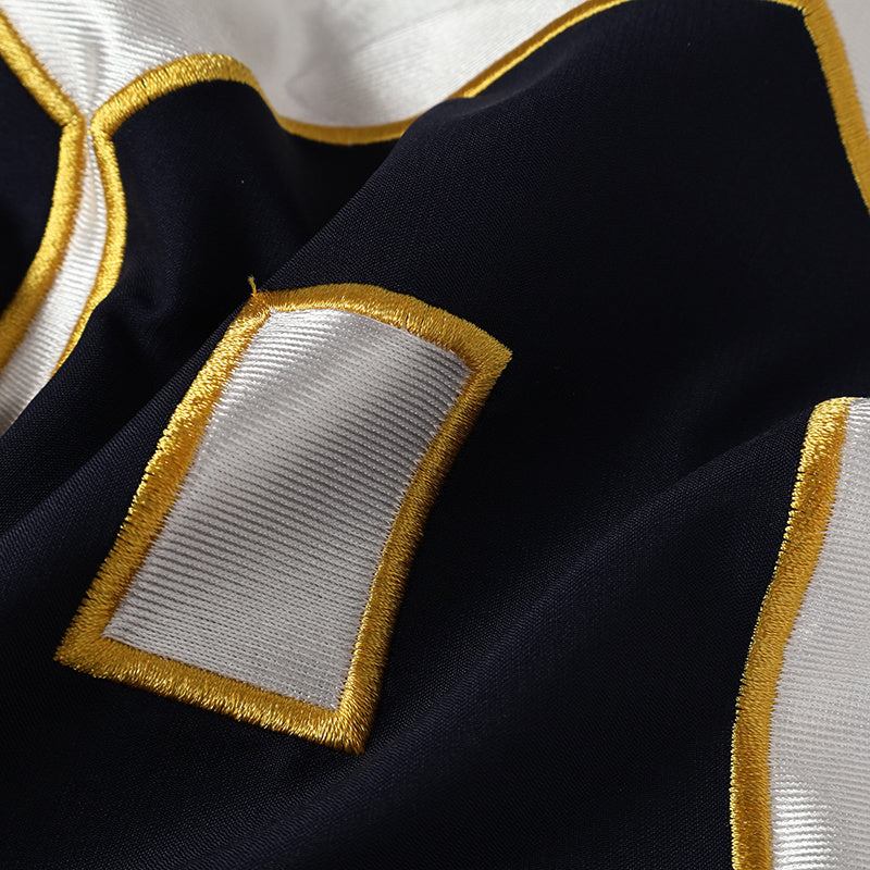 Close-up of a navy street jersey with white varsity number patches and gold trim stitching