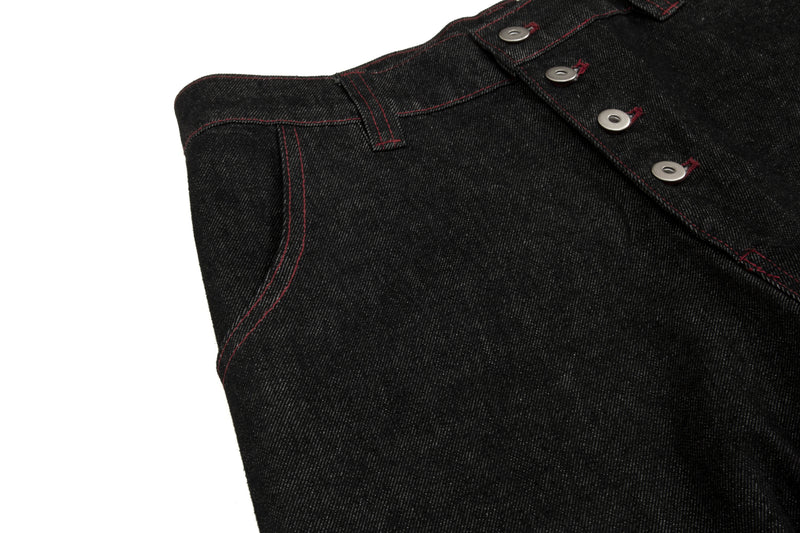 Close-up of black denim waistband with button fly and contrast red topstitching