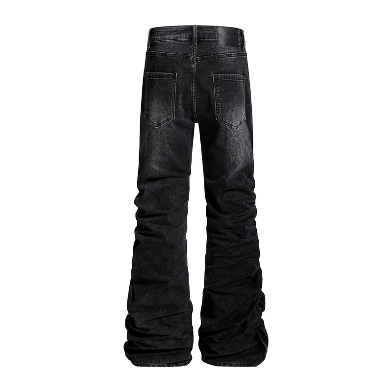 Back view of black washed flare jeans with stacked legs and patch pockets