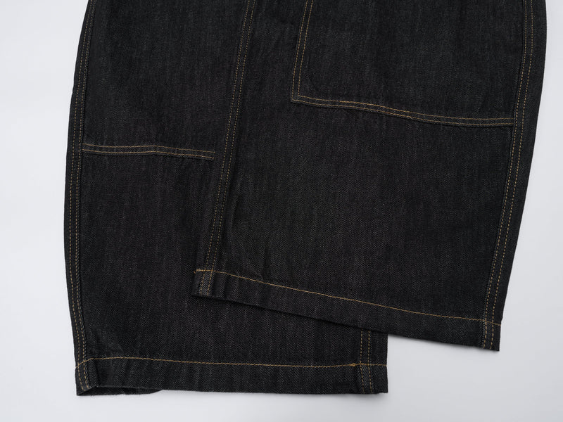 Lower leg close-up of dark wash jeans showing oversized carpenter pocket detail