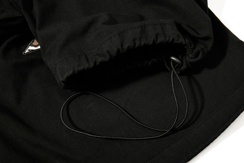 Close-up of black cargo pants elastic drawcord hem at the ankle
