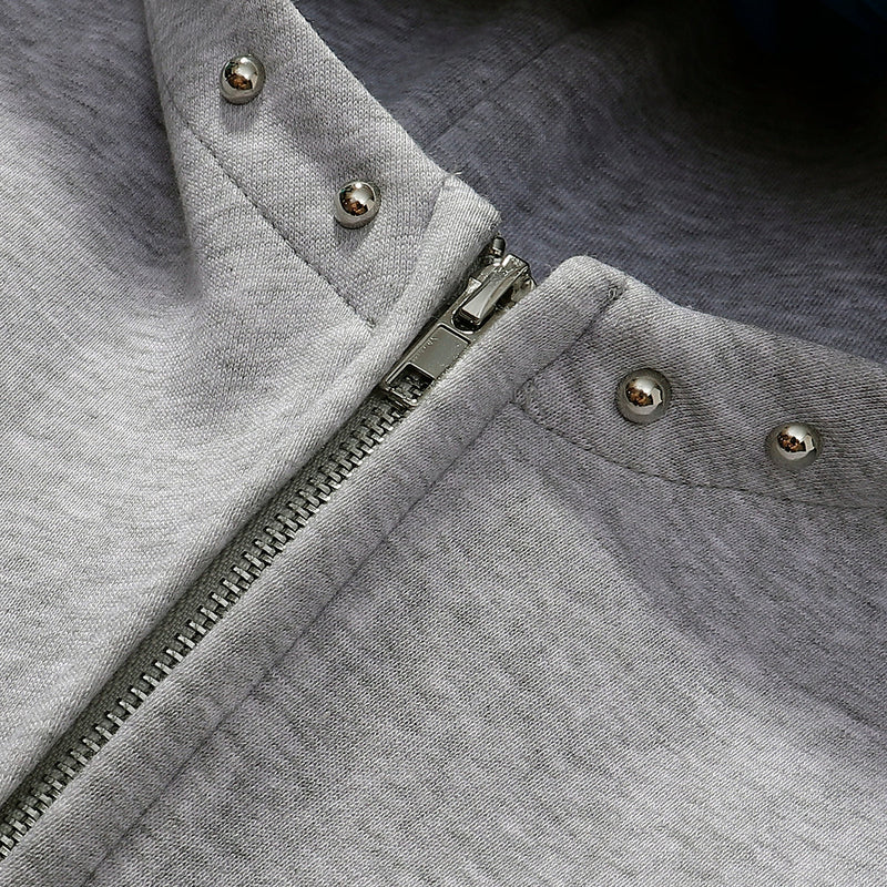 Gray zip hoodie close-up of zipper pull and studded hood seam