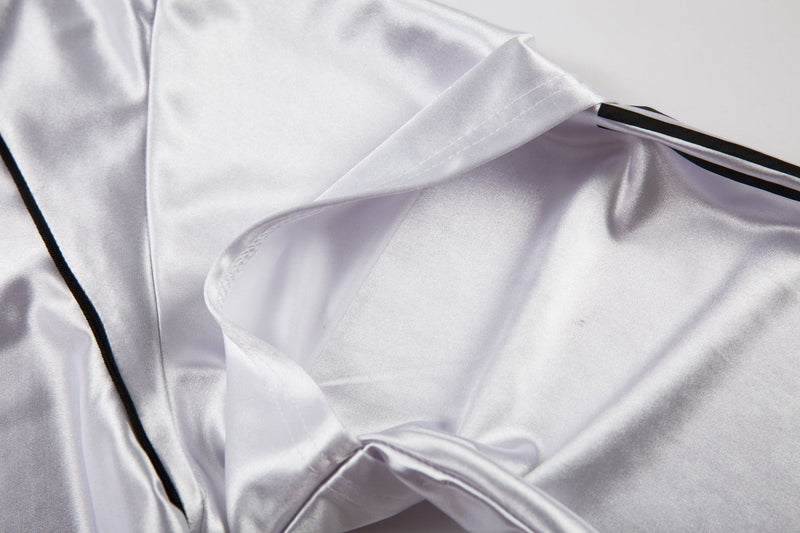 Close-up of white jersey shoulder and sleeve opening with black side piping