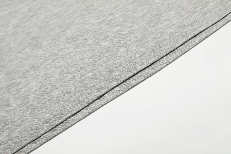 Close-up of gray tee sleeve fabric and hem seam