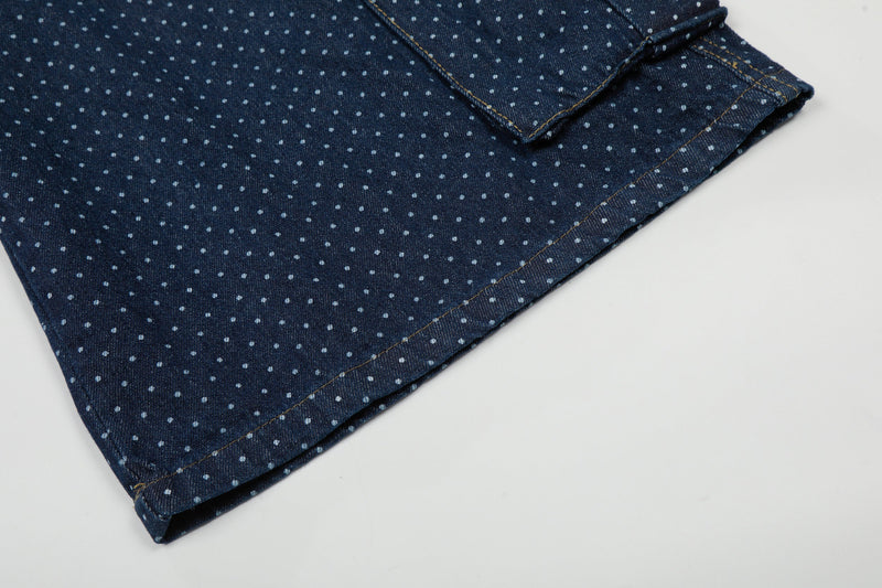 Folded hem close-up of navy polka dot denim cargo shorts with stitched edge