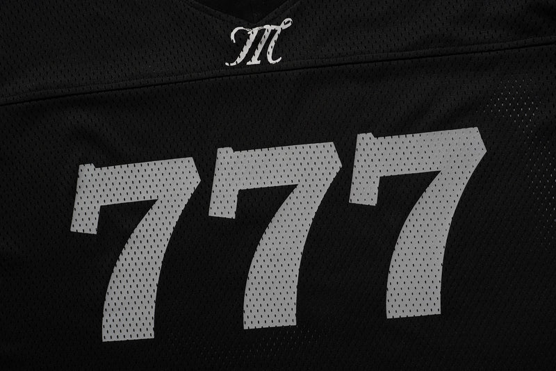 Black jersey chest close-up with white monogram and large 777 print